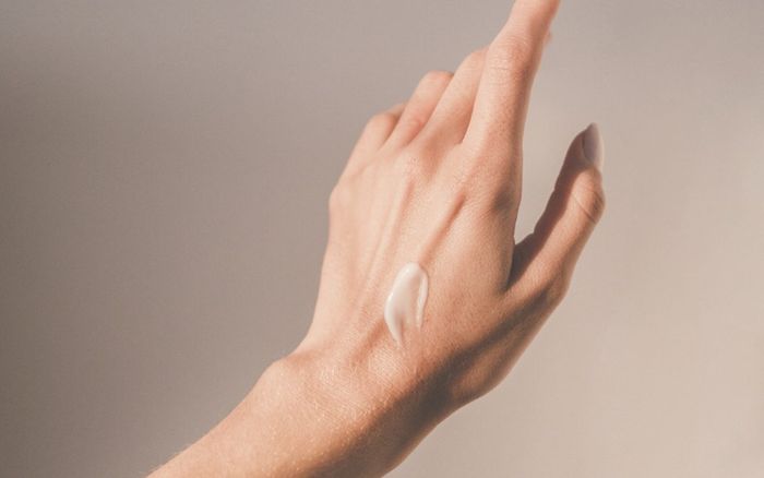 Hand with skincare cream applied
