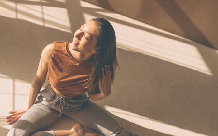 Woman sitting calmly in warm sunlight